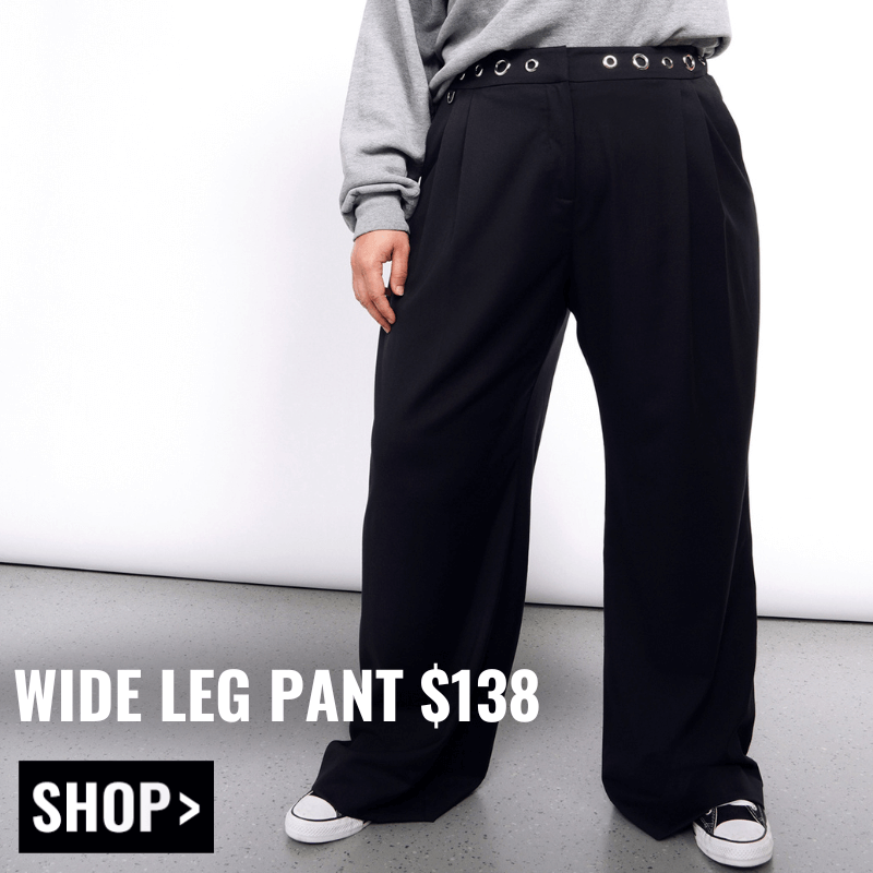 Image shows model from waist down wearing the Debbie Harry x Wildfang Wide Leg Pant in black and converse sneakers. Text overlay reads WIDE LEG PANT $138 and button below reads SHOP.