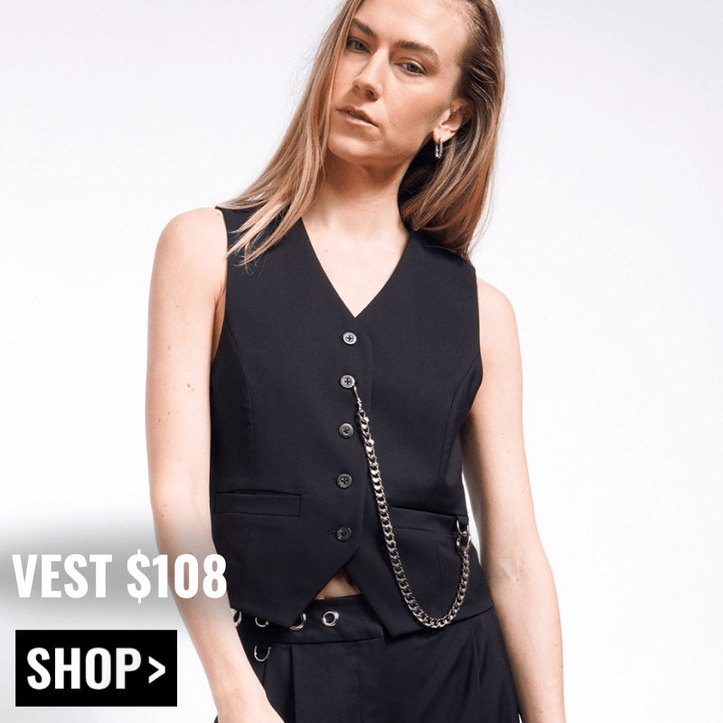 Model with long blonde hair wears The Debbie Harry x Wildfang Vest in black. Text overlay reads VEST $108  and button below reads SHOP.