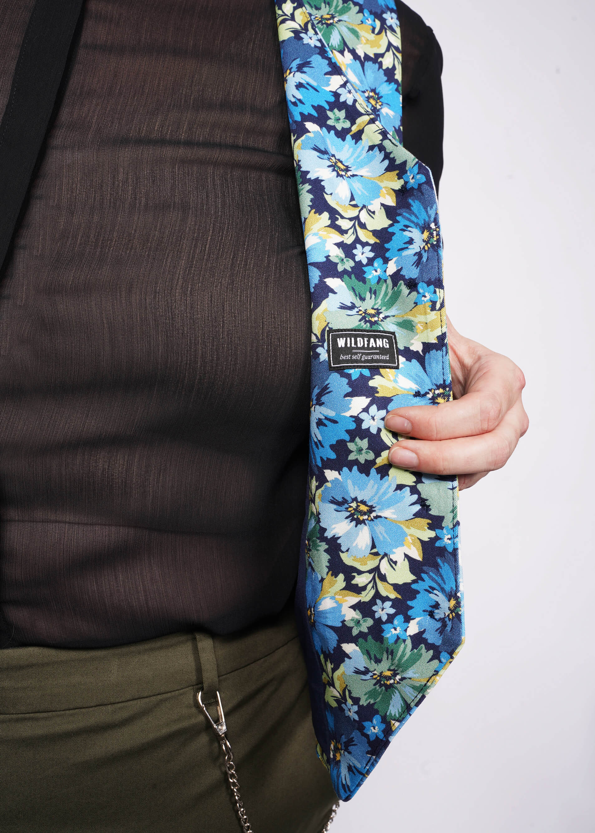 Close up of person showing lining of floral printed vest with WILDFANG label.