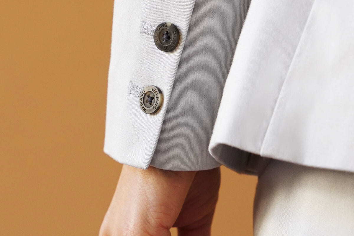 Close up of grey blazer cuff and buttons